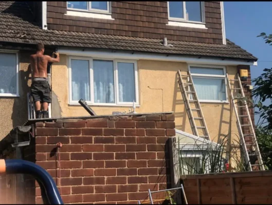 Trident Roofing Ltd expert performing cheap roofing repairs in Plymouth on a residential home using ladders.